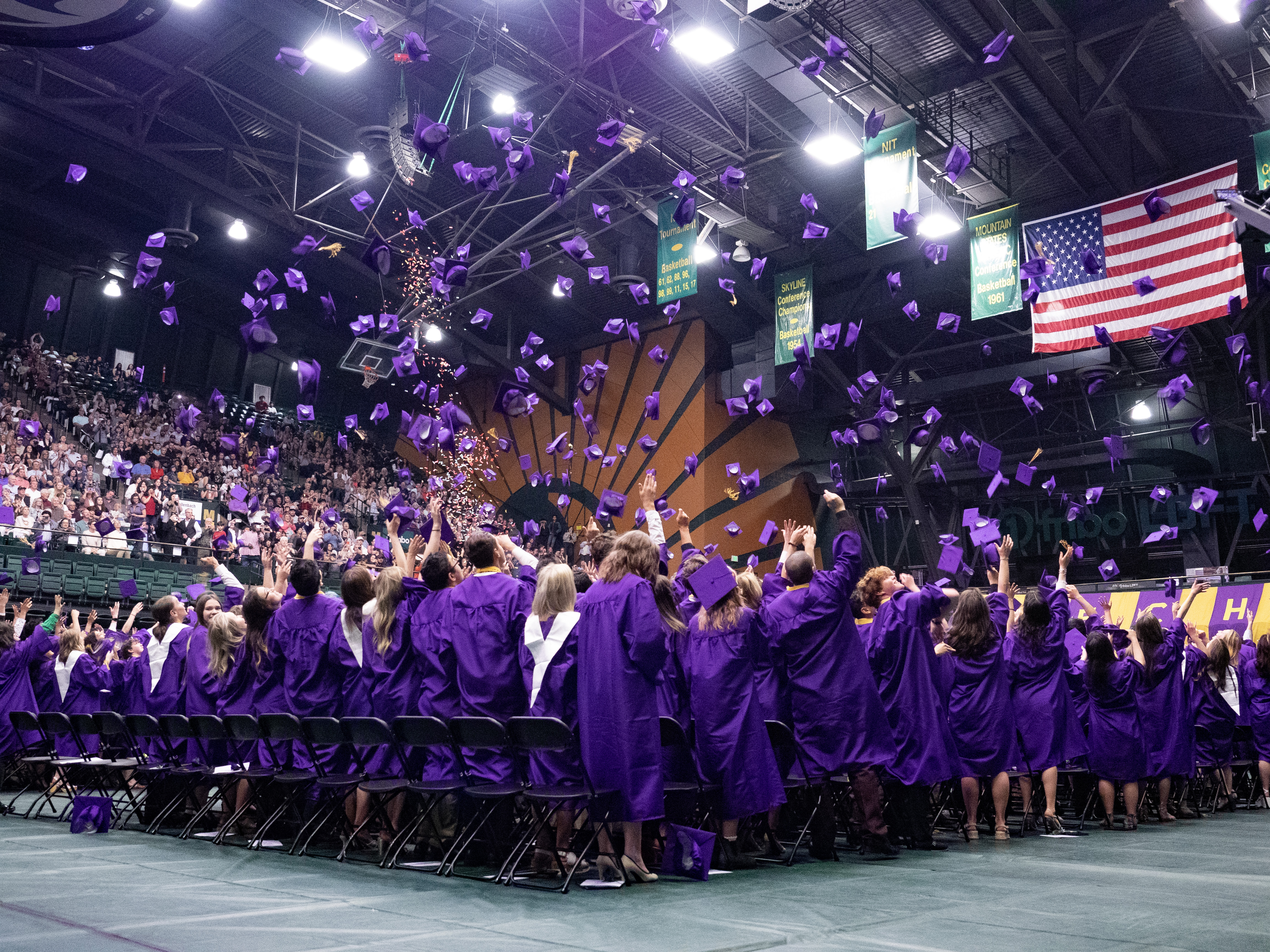 PSD high schoolers throw their caps in the air at 2023 graduation.