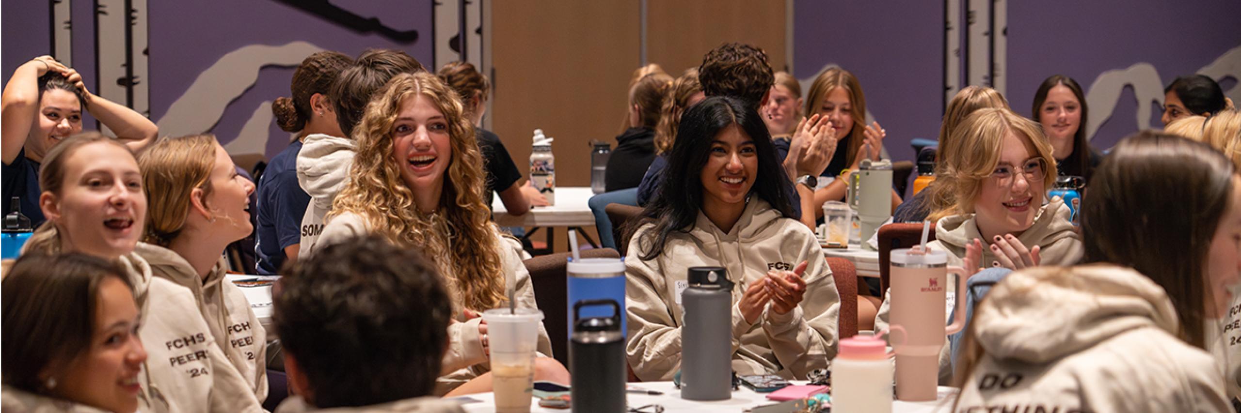 High school students laugh together at the 2023 Peer Summit.